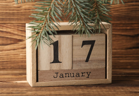 Wooden block calendar with date January 17 and pine tree on wooden backgroundの写真素材