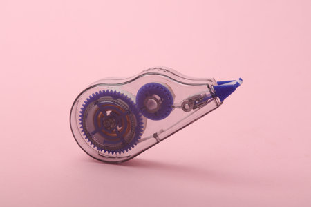 Tape corrector floating on pink background.
