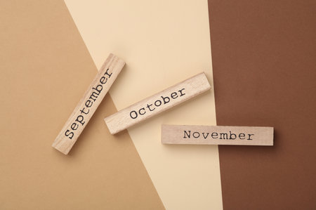 Wooden signs with autumn months on a beige background. September, october and novemberの写真素材
