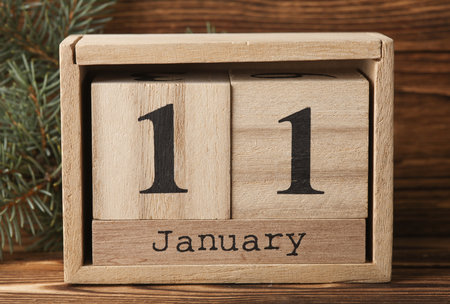 Wooden block calendar with date January 11 on wooden background