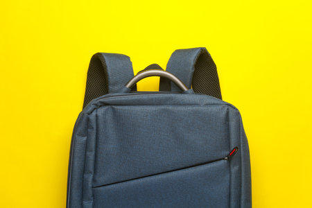 Fabric backpack on yellow background. Top view