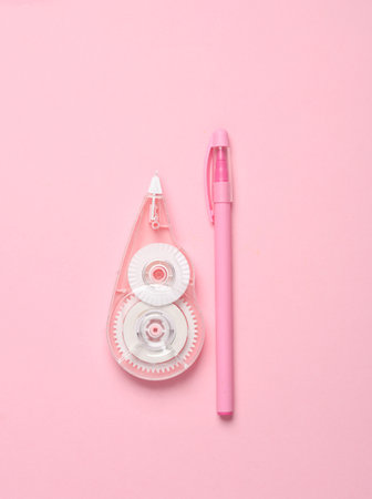 Tape corrector with pen on pink background. Top viewの写真素材