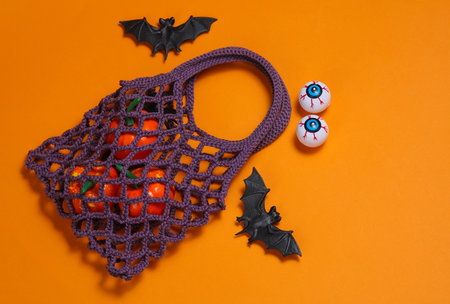 String bag with Halloween decor on an orange background. Top viewの写真素材