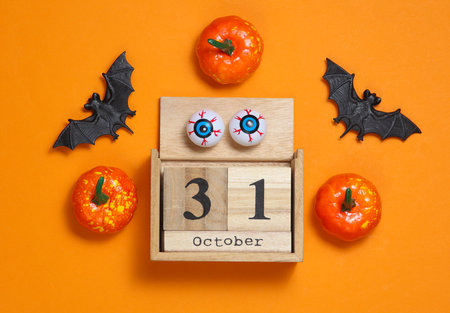 October 31 wooden calendar with Halloween decor on orange backgroundの写真素材
