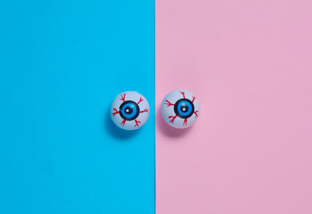 Eyeballs on pink blue background. Minimalistic Halloween still lifeの写真素材
