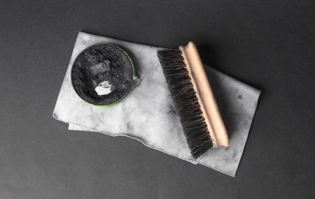 Shoe polish, rag and brush on a black background. Leather shoe care