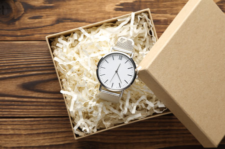 Wrist watch in craft box with filler on wooden background. Product packagingの写真素材