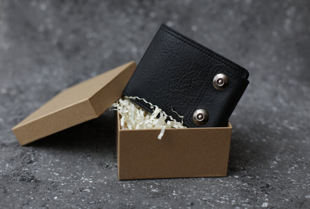 Leather wallet in Cardboard craft box with filler on concrete background
