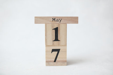 Wooden block calendar with date May 17 on a concrete background