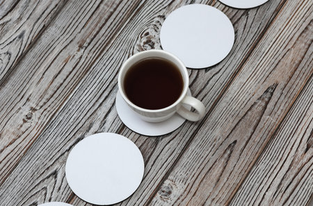 White round empty coasters Mockup and coffee cup on white wooden backgroundの写真素材