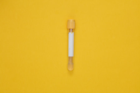 Medical empty blood tube on yellow background