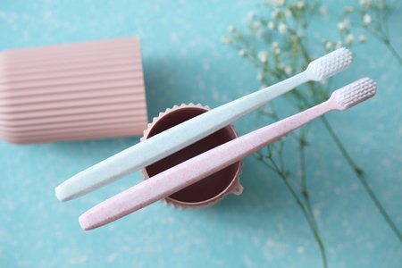 Toothbrushes with plastic organizer case on blue concrete background