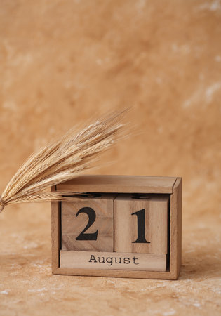 Wooden block calendar with the date August 21 on a beige concrete background