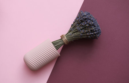 Dry lavender bouquet with vase on pink burgundy backgroundの写真素材