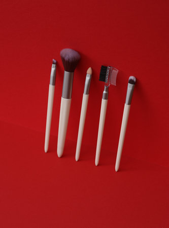 Set of makeup brushes on a red background