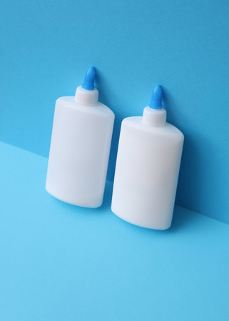 Two bottles of pva glue on blue backgroundの写真素材