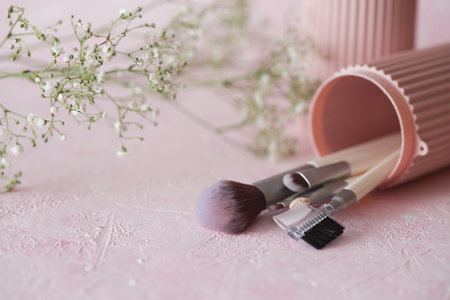 Set of makeup brushes in storage organizer on pink concrete backgroundの写真素材