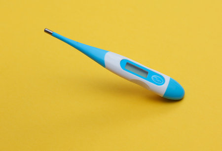Electronic thermometer floating on yellow background.の写真素材
