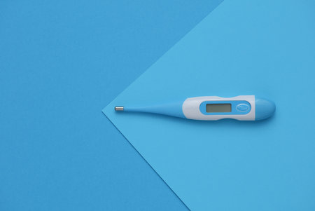 Electronic thermometer on blue background. Top viewの写真素材