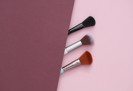 Assorted makeup brushes on pink burgundy backgroundの写真素材
