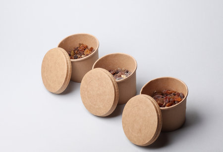 Disposable cardboard boxes, food containers with oatmeal and raisins on a white background.の写真素材