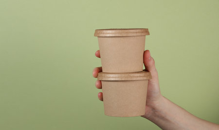 Food paper containers, cardboard round disposable packaging boxes in hand