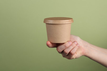 Food paper container, cardboard round disposable packaging box in handの写真素材