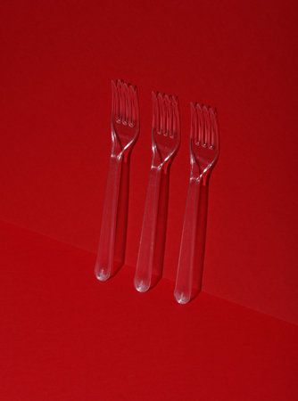 Plastic transparent forks on a red background