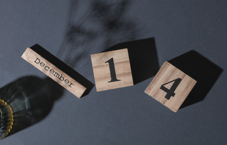 Wooden blocks with the date December 14 on a dark background. Top view