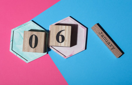 Wooden block calendar with the date January 06 on pink blue background. Top viewの写真素材
