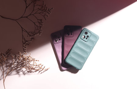 Smartphone protective covers on a beige background with shadowの写真素材