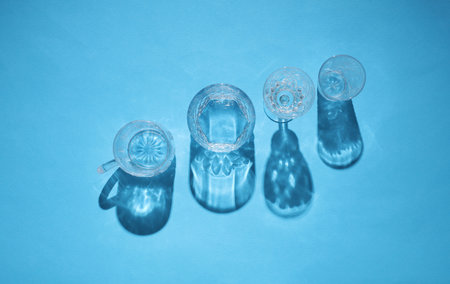 Drink glasses with shadow on a blue background. Top view. Minimalism, creative layout