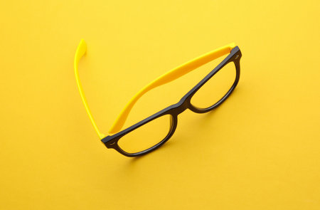 Stylish fashion eyeglasses on a yellow background. Top viewの写真素材