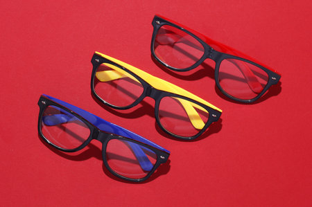 Stylish fashion eyeglasses on red background. Top viewの写真素材