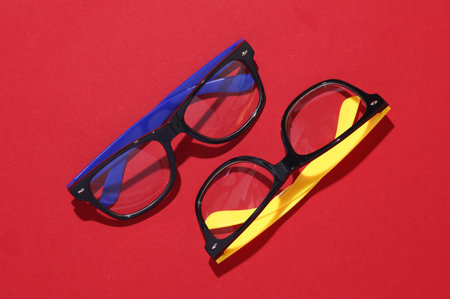 Stylish fashion eyeglasses on red background. Top view