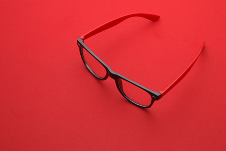 Stylish fashion eyeglasses on a red background.の写真素材