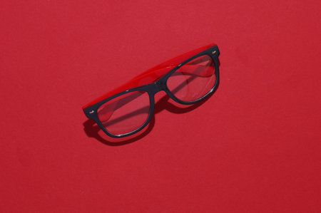 Stylish fashion eyeglasses on red background. Top viewの写真素材