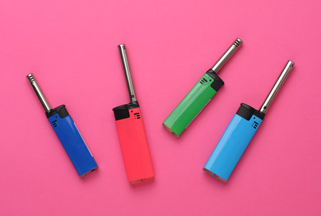 Household lighters on pink background. Top view