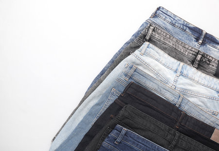 Assortment of different jeans on a white background