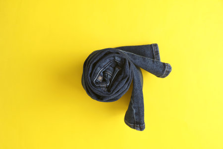 Rolled up jeans pants on a yellow background. Top viewの写真素材