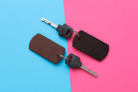 Leather keychains with keys on a pink blue backgroundの写真素材