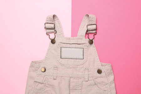 Children's overalls on pink background. Top view