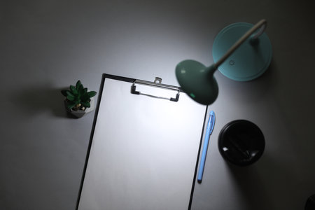 LED table lamp illuminates clipboard. Energy saving, business concept. Flat layの写真素材