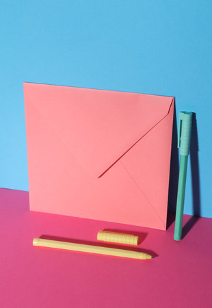 Envelope with pens on blue-pink pastel backgroundの写真素材