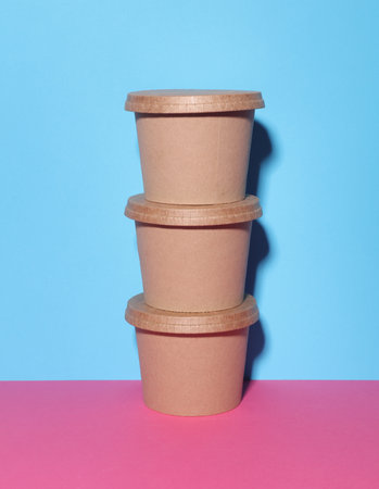 Kraft Food product containers on blue-pink background. Eco conceptの写真素材
