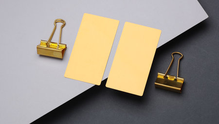 Gold business cards and binders on a gray backgroundの写真素材