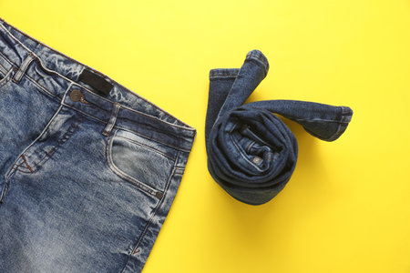 Rolled up jeans pants on a yellow background. Top viewの写真素材