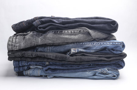 Stack of Many jeans pants on white backgroundの写真素材