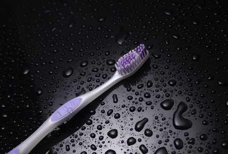 Toothbrush in water drops on a black backgroundの写真素材