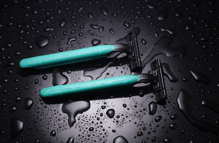Razors in water drops on a black background
